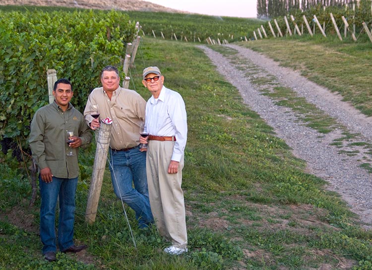 Winemaker Jose Mendoza (left) and director of winemaking Greg Powers standing with his father and winery founder, Bill Powers, a revered pioneer of Washington’s wine industry